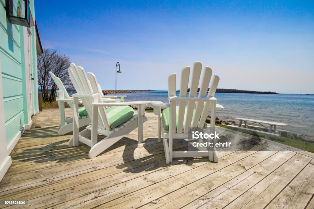 Adirondack chairs on a wooden deck with a view of Lake Huron at the Mackinaw Island Public Library.